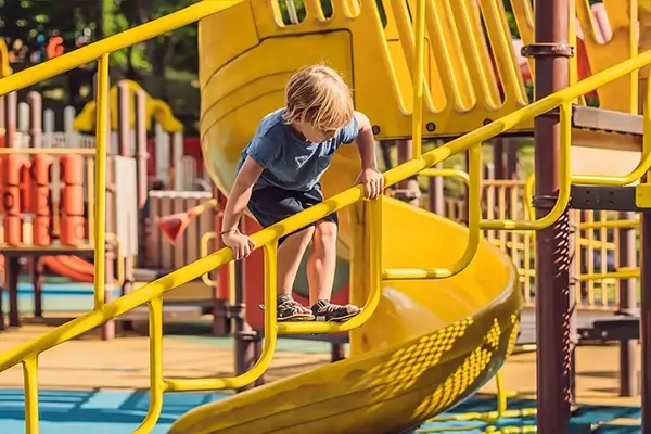 Young child playing on a playground play frame