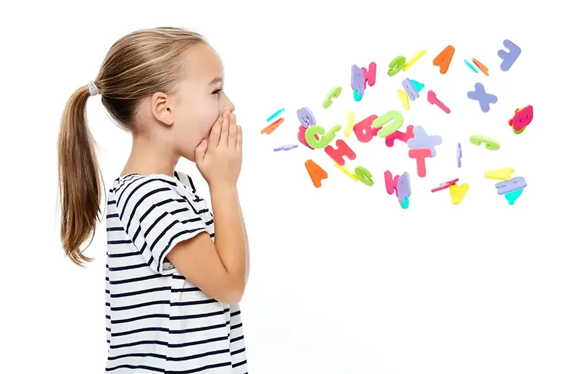 Young girl shouting out with colourful letters from the alphabet flying out