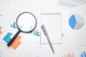 Top view of printed data sheets with a magnifying glass laid over