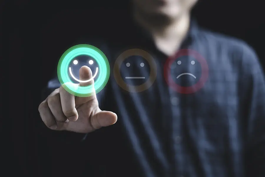 Businessman selecting a smiley face on computer