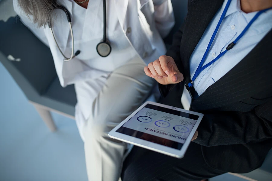 high angle view of a manager and medical member of staff looking at a tablet
