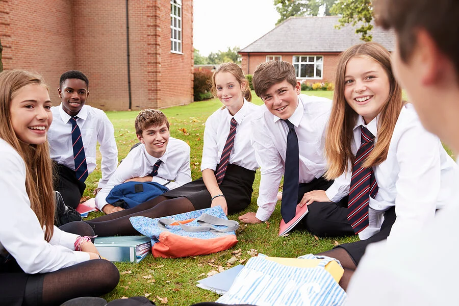 group of teenagers in uniform outside of school