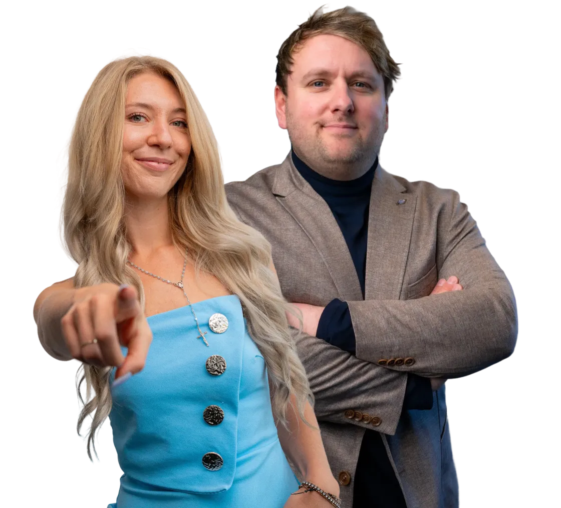 Confident woman in a blue dress pointing forward with a smiling man in a brown blazer standing with arms crossed behind her.