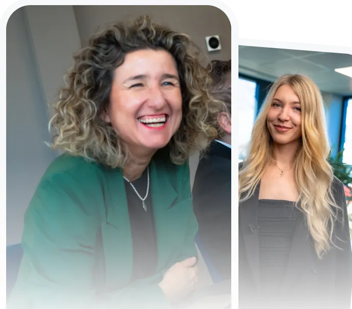 Two professional women smiling indoors; one with curly hair wearing a green blazer, the other with long blonde hair wearing a black blazer.