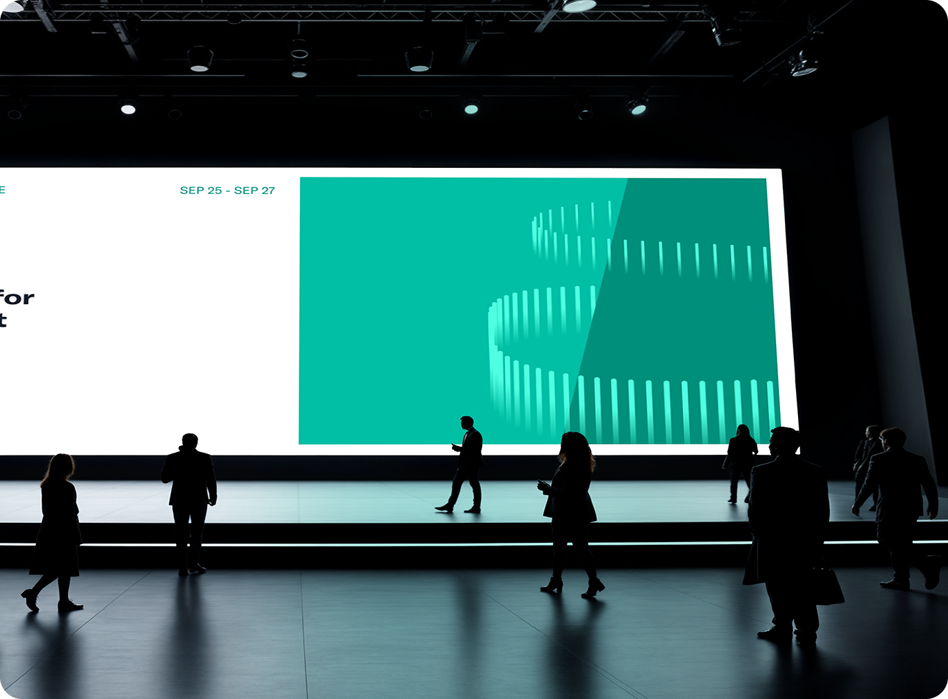 Silhouettes of people walking and standing in front of a large illuminated presentation screen in a dark conference hall.