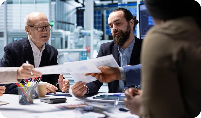 Business team in a modern office discussing documents and data charts during a meeting.