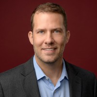 Hansel Dobbs — Chief Appraiser at Appraisify, wearing a blazer against a crimson studio backdrop
