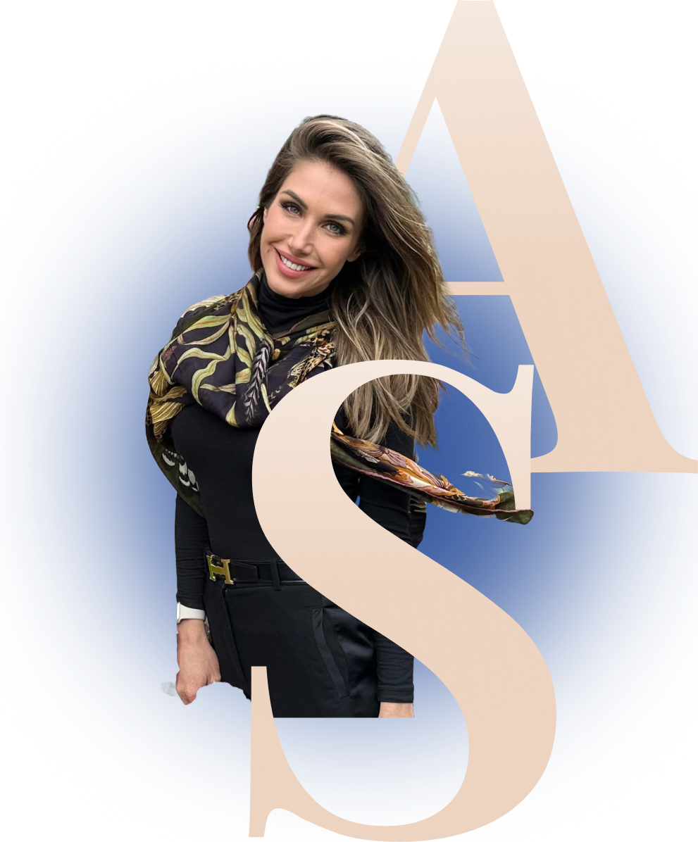 Smiling woman with long hair wearing a black top, patterned scarf, and black pants against a blue background with large beige letters A and S.