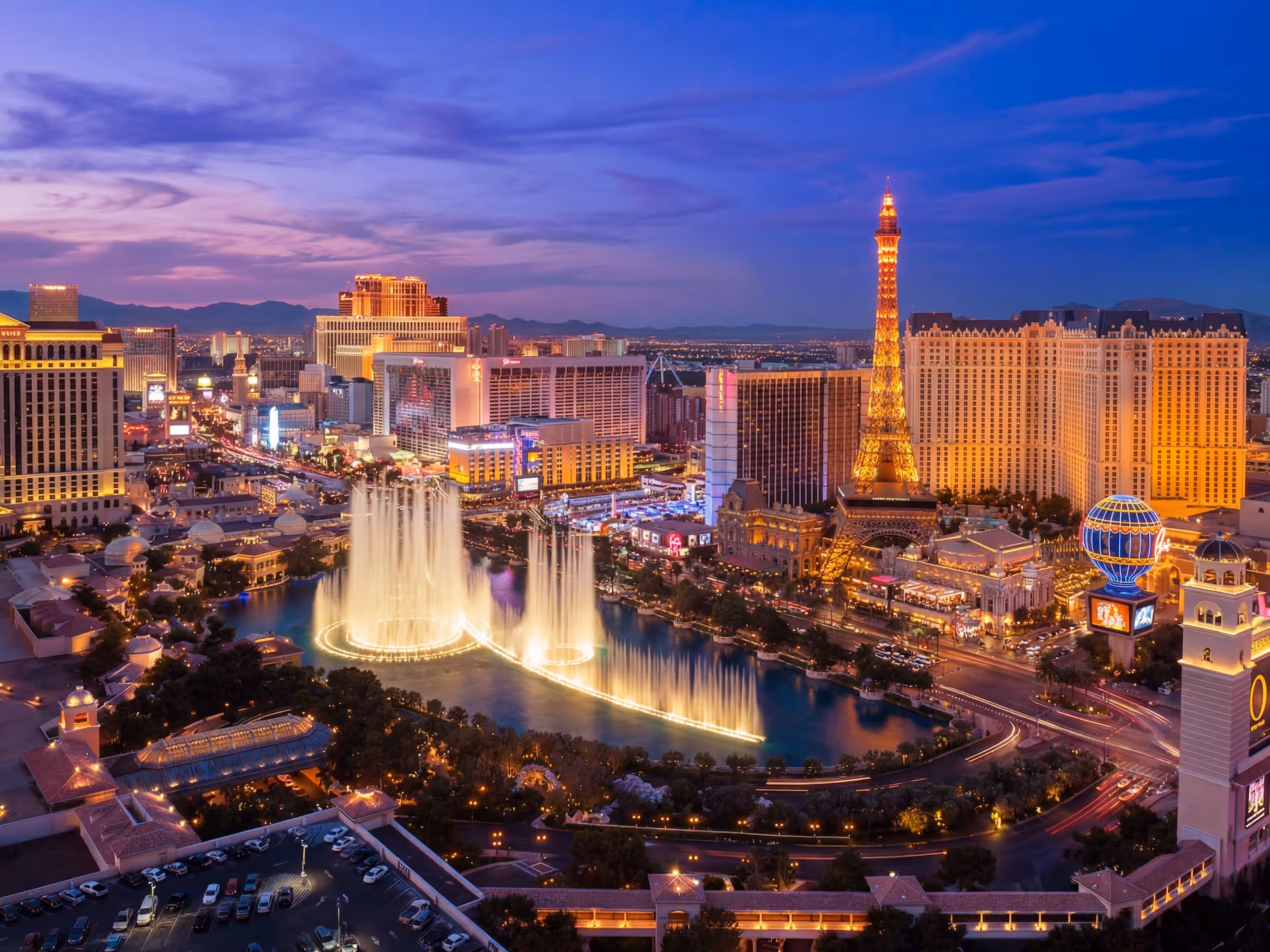 Partial side view of the ancient Roman Colosseum illuminated by a colorful orange and pink sunset sky.