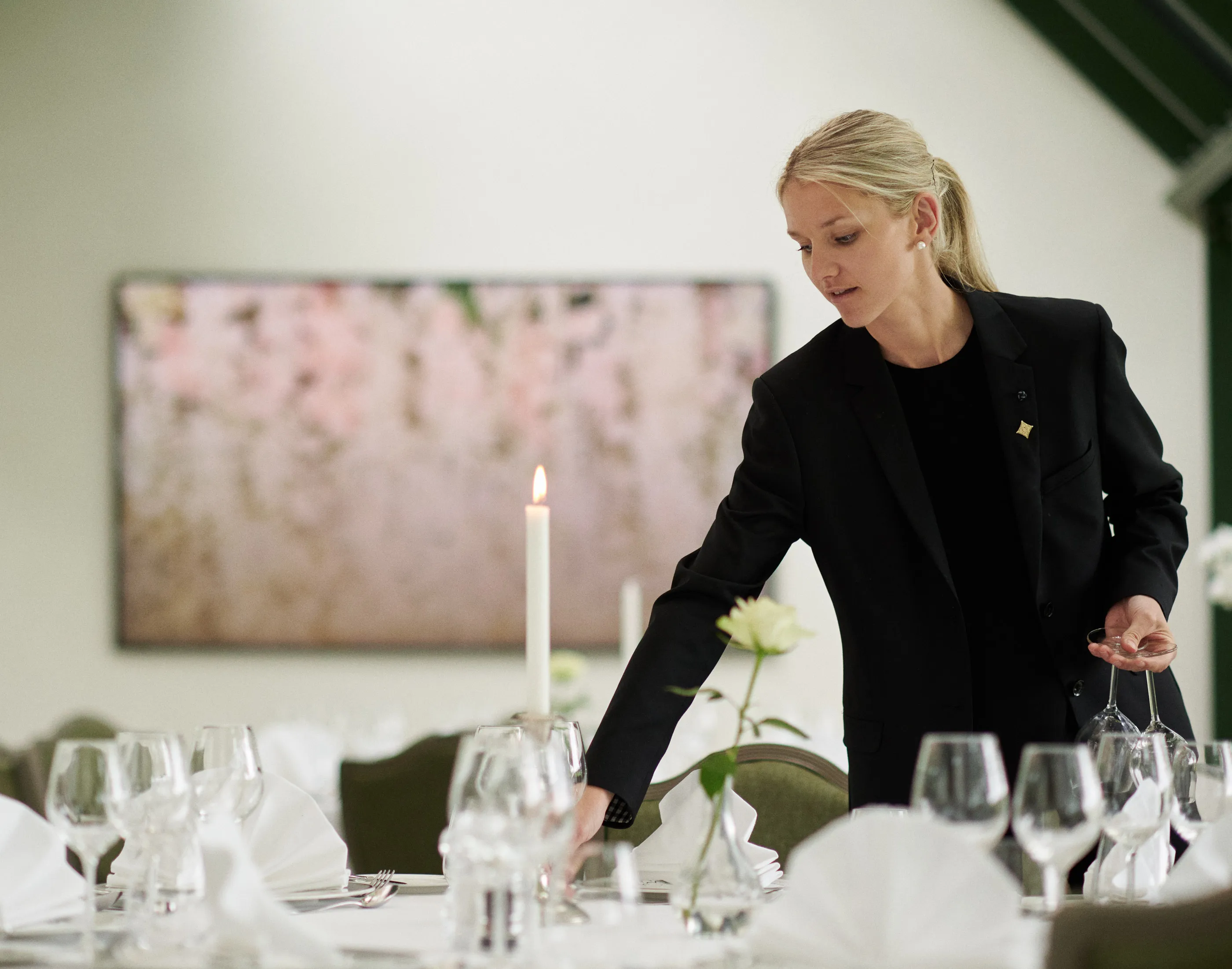 Kvinna som dekorerar ett bord med glas och ljus