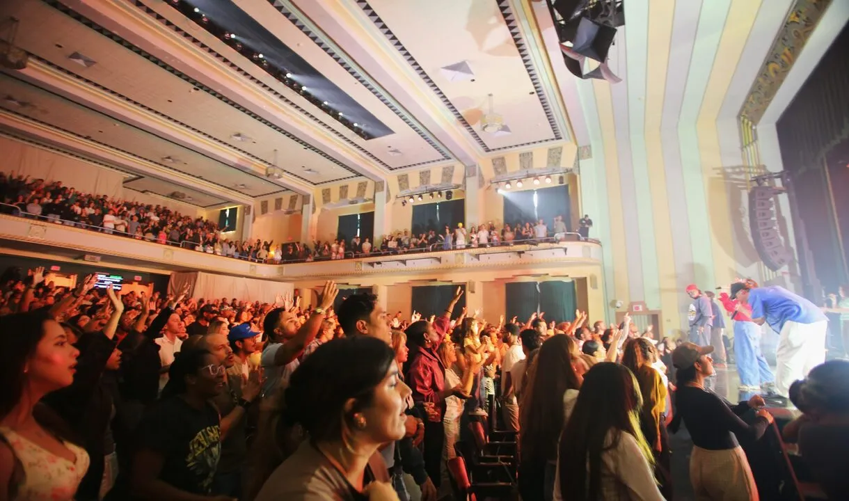 A packed theatre worshipping with VOUS Worship