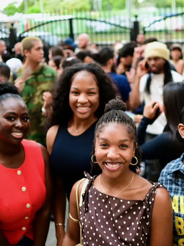 Friends smiling together in a crowd at VOUS