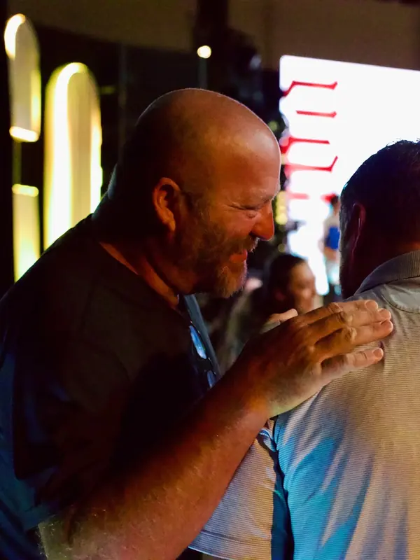 Two men embrace during a VOUS service