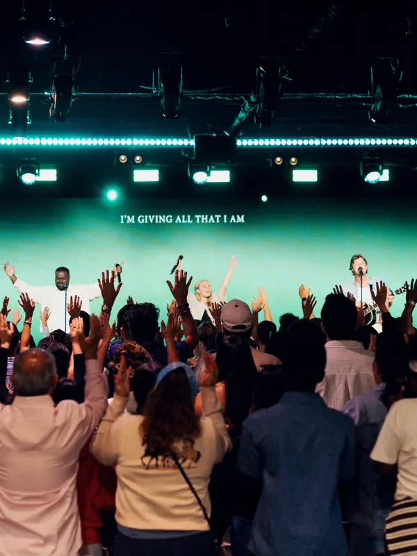 A crowd with hands raised in worship