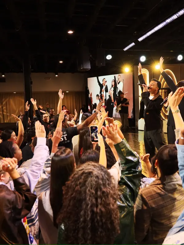 People worshipping with hands raised at a VOUS night
