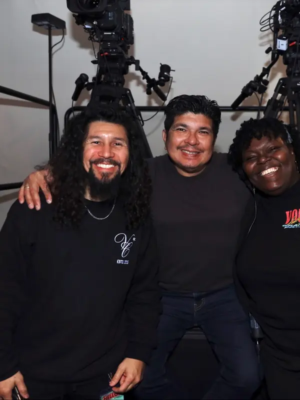 Three friends smiling backstage at VOUS