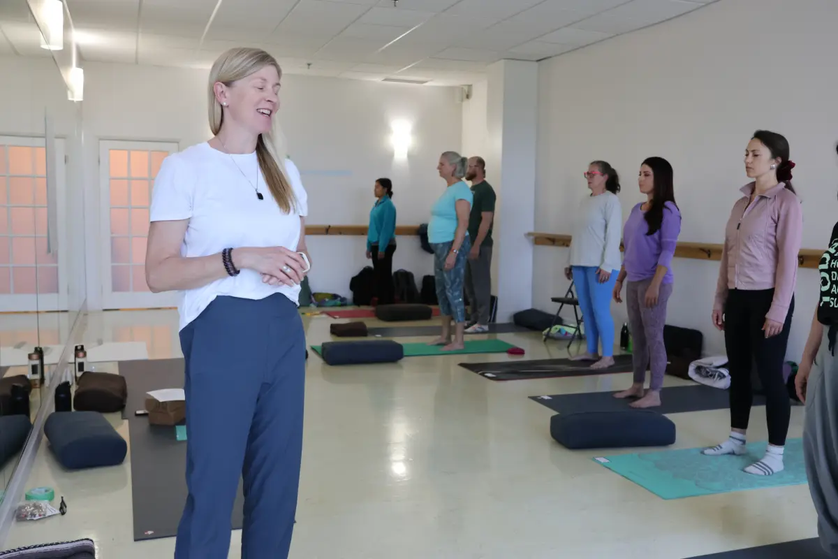 Carrie leading a somatic class in a bright studio