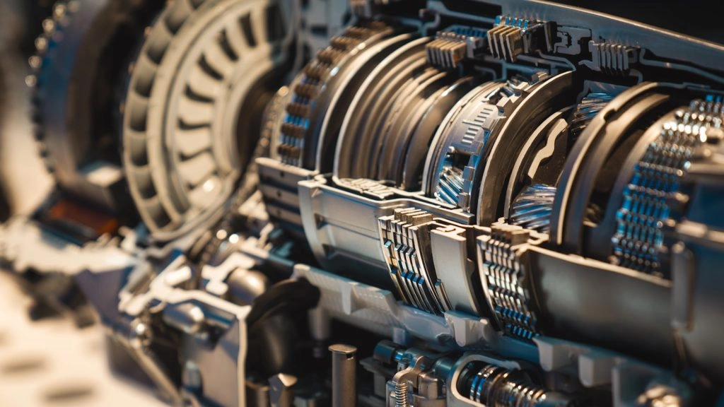 Close-up of an intricate cross-section of a modern vehicle's automatic transmission, showing the detailed arrangement of gears, clutches, and internal mechanical components