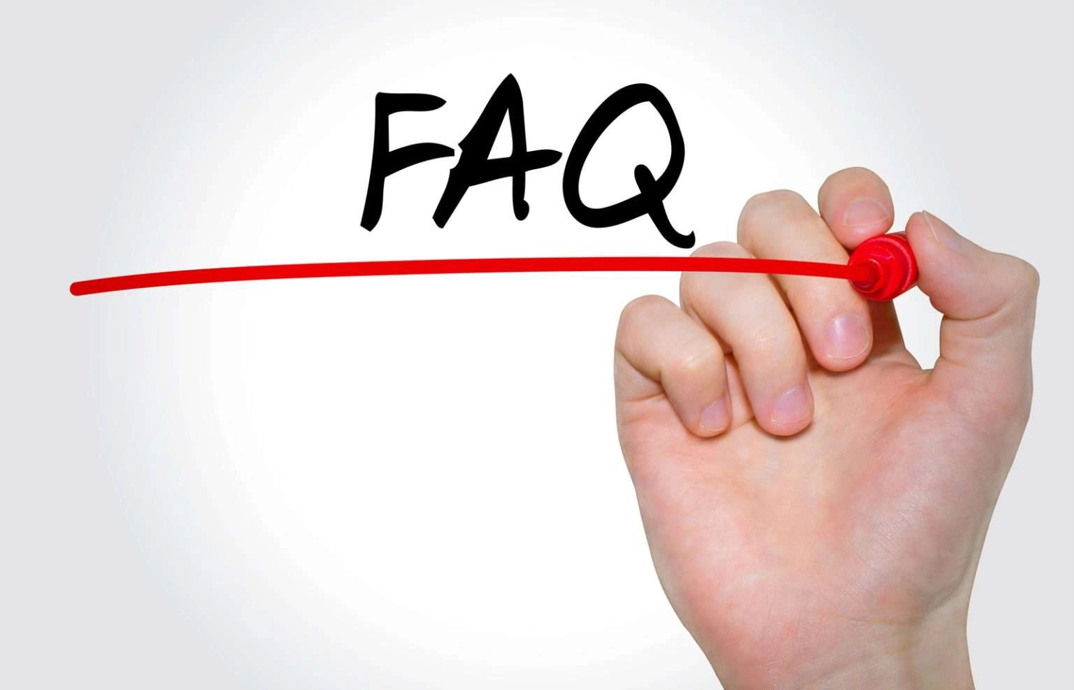 A close-up shot of a hand holding a red marker, drawing a long horizontal line beneath the large black letters "FAQ" on a plain light grey background