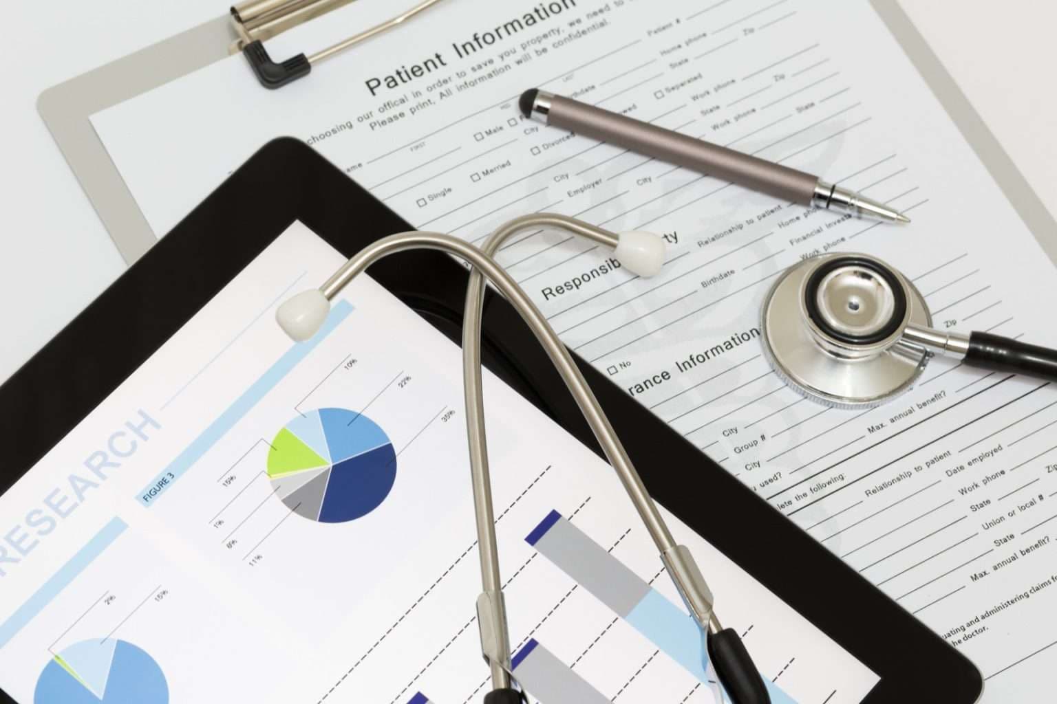  Treść wiadomości Gemini A medical stethoscope lies across a tablet showing research charts and a printed "Patient Information" form on a clipboard, along with a silver pen