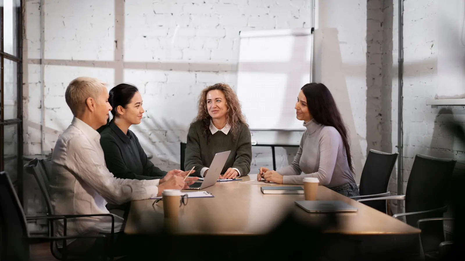 A team meeting in a conference room discussing strategies to Calculate Incremental Profit through collaborative analysis.
