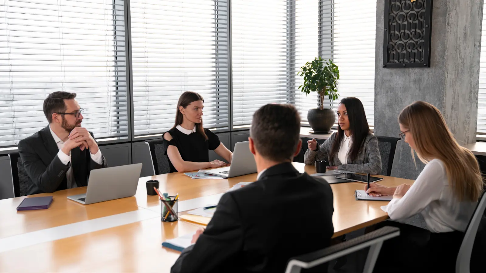 Corporate professionals meeting in a boardroom to discuss Weekly KPIs that connect finance and sales performance.