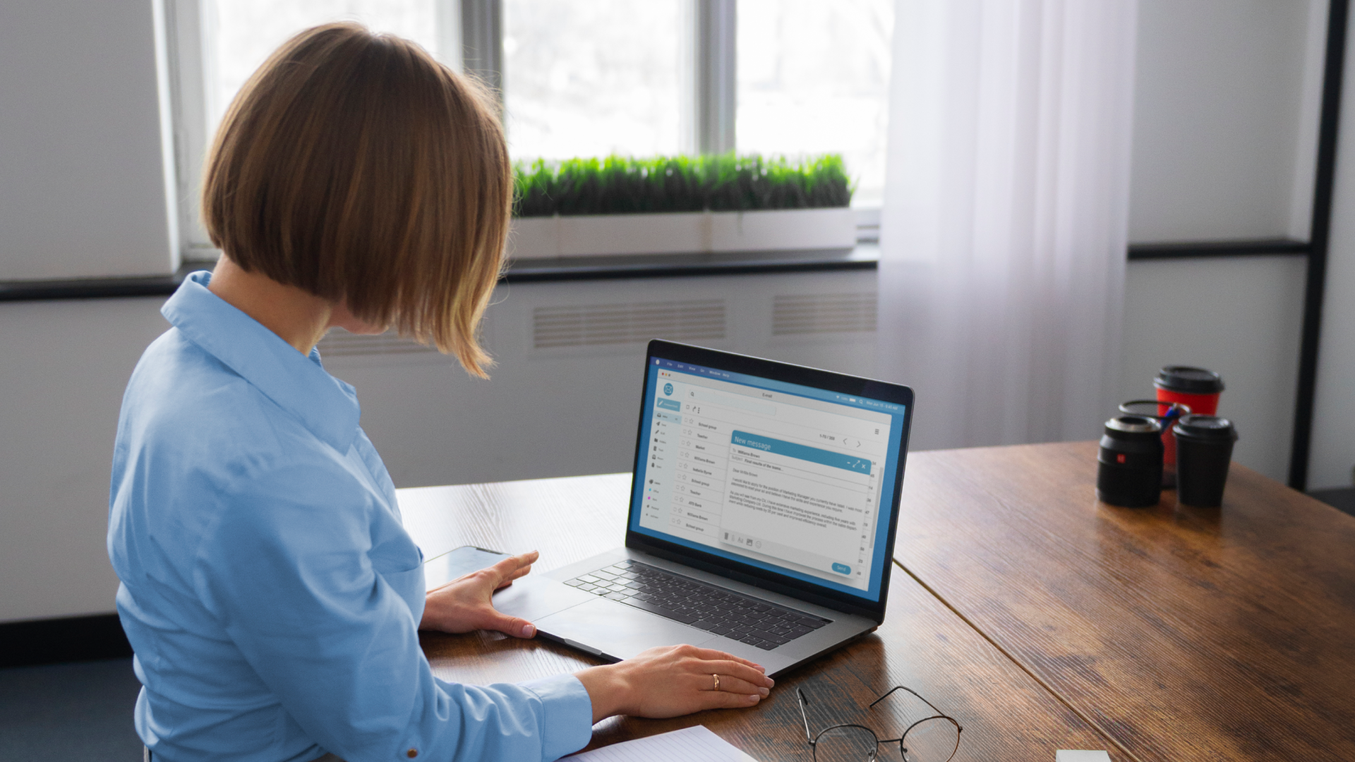 Finance professional reviewing an email inbox on a laptop while managing UNFI deduction remittances.