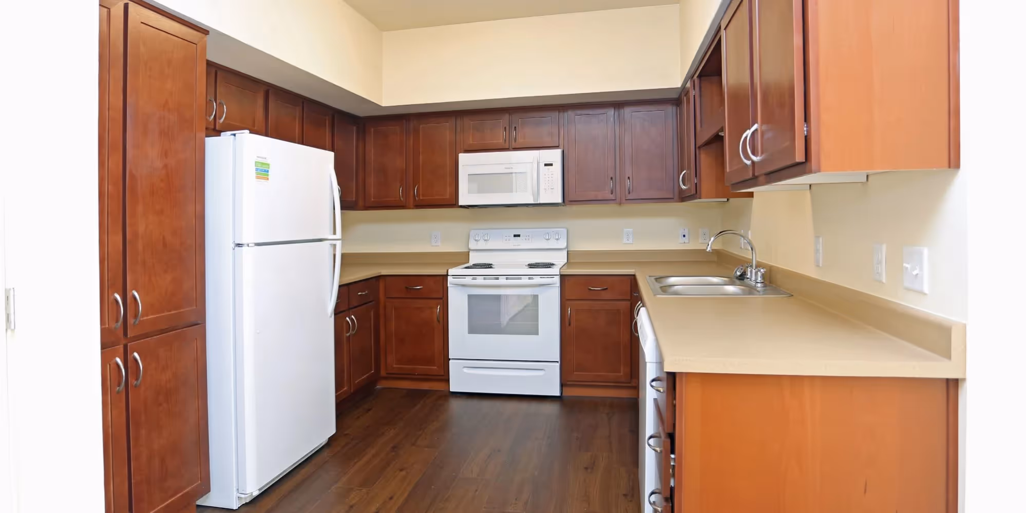 Kitchen with brown cabinets and white appliances