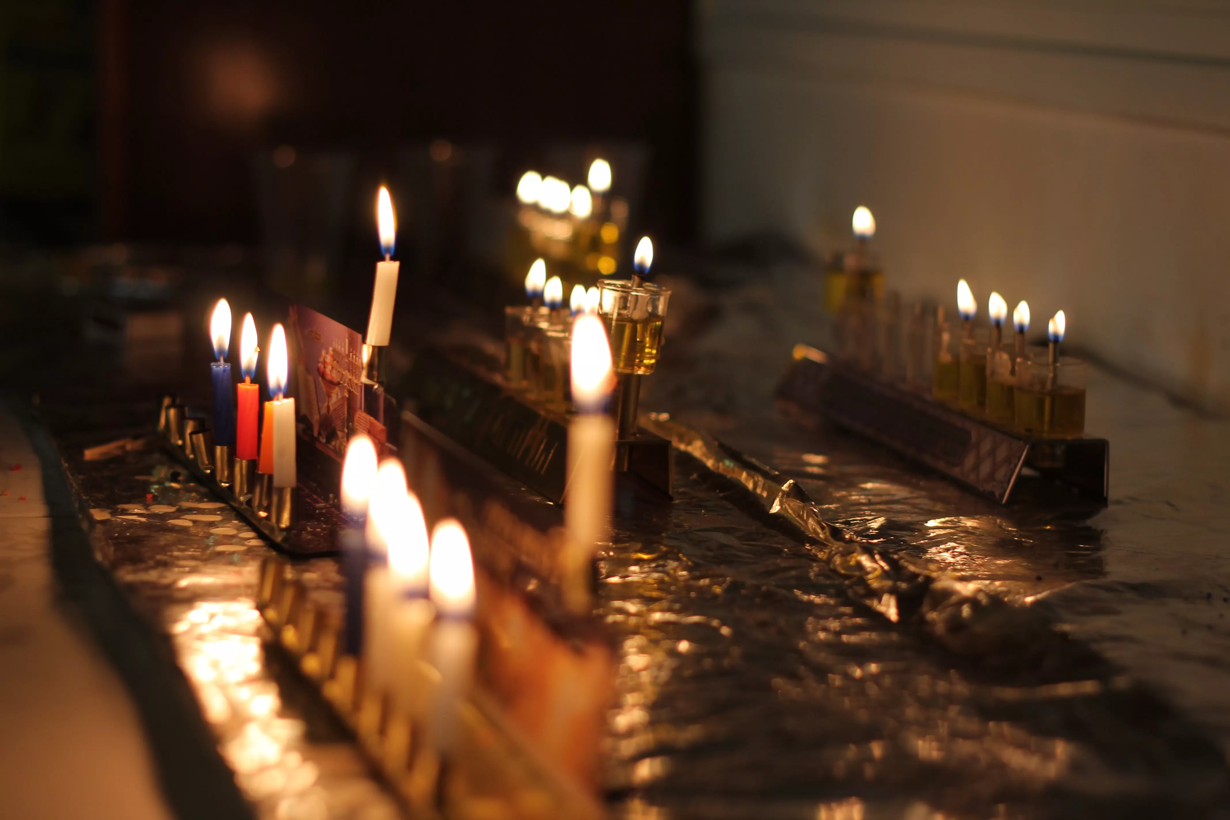 Candles lit on a dining table in a dark room