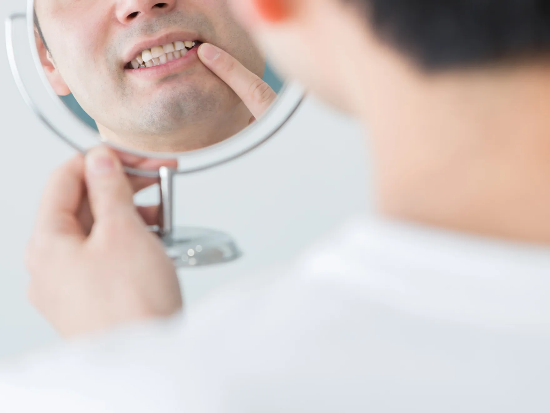 A man is looking at his reflection in the mirror.