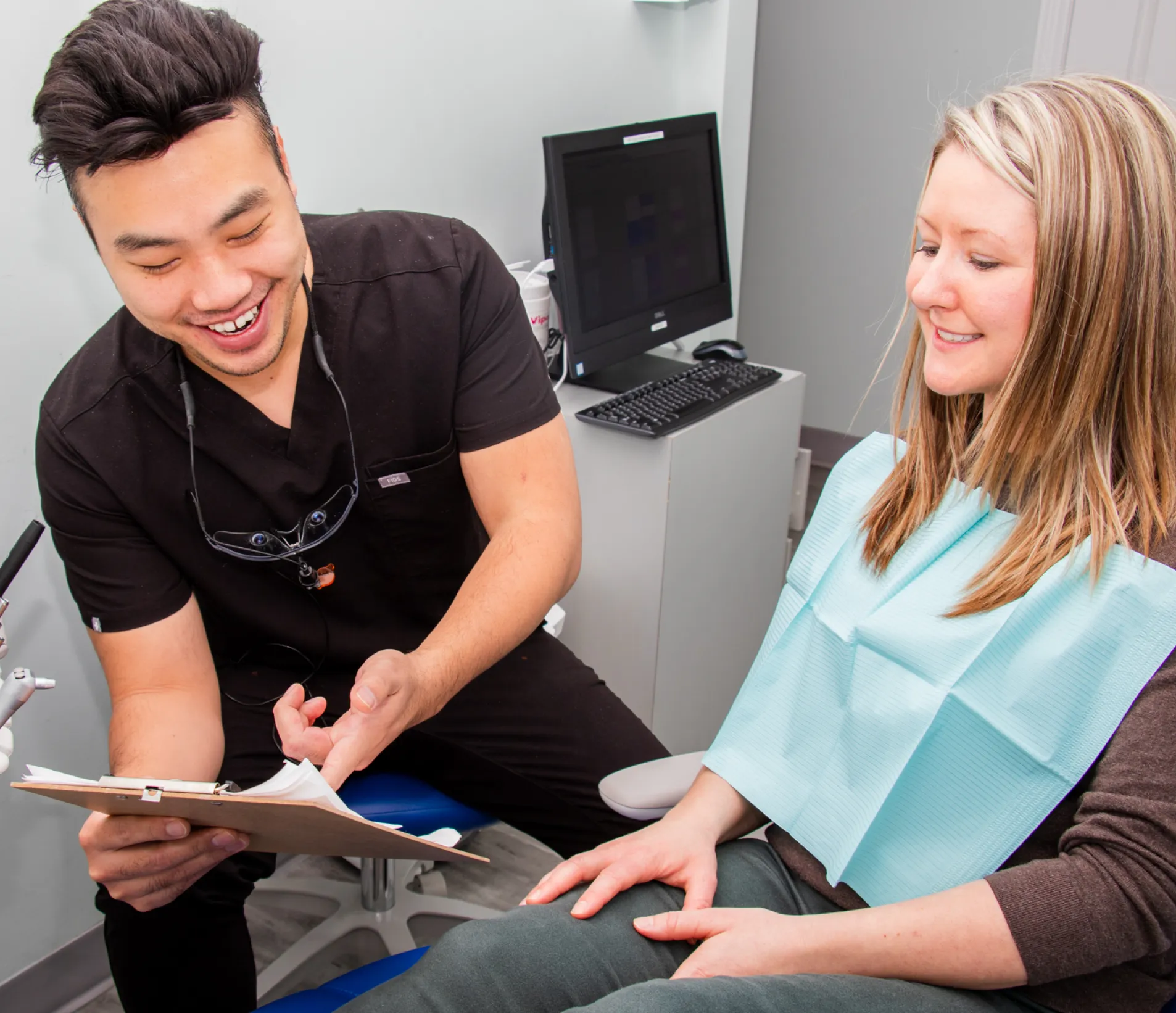 A man sitting in a dentist chair next to a woman.