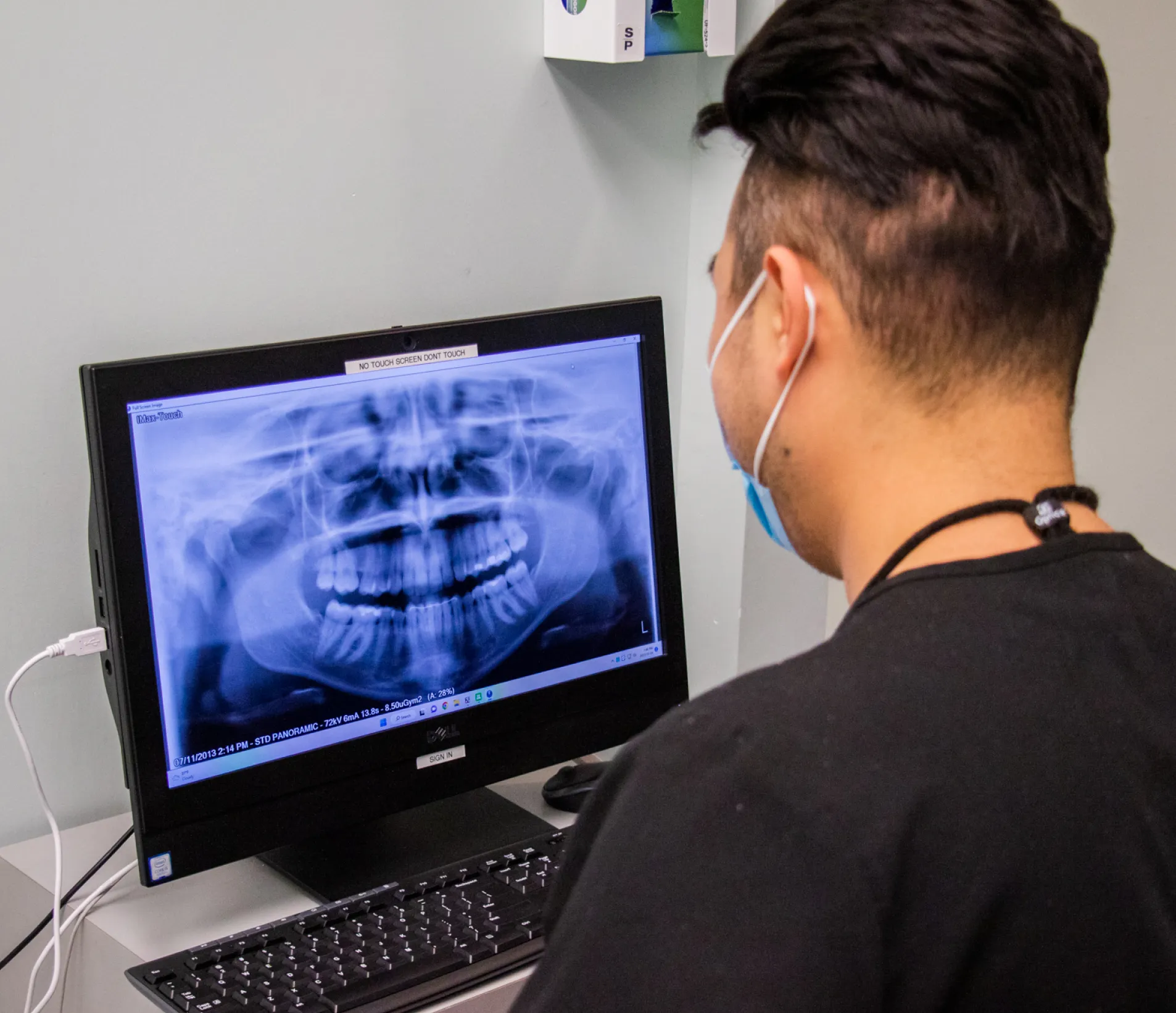 A man wearing ear buds looking at a computer screen.