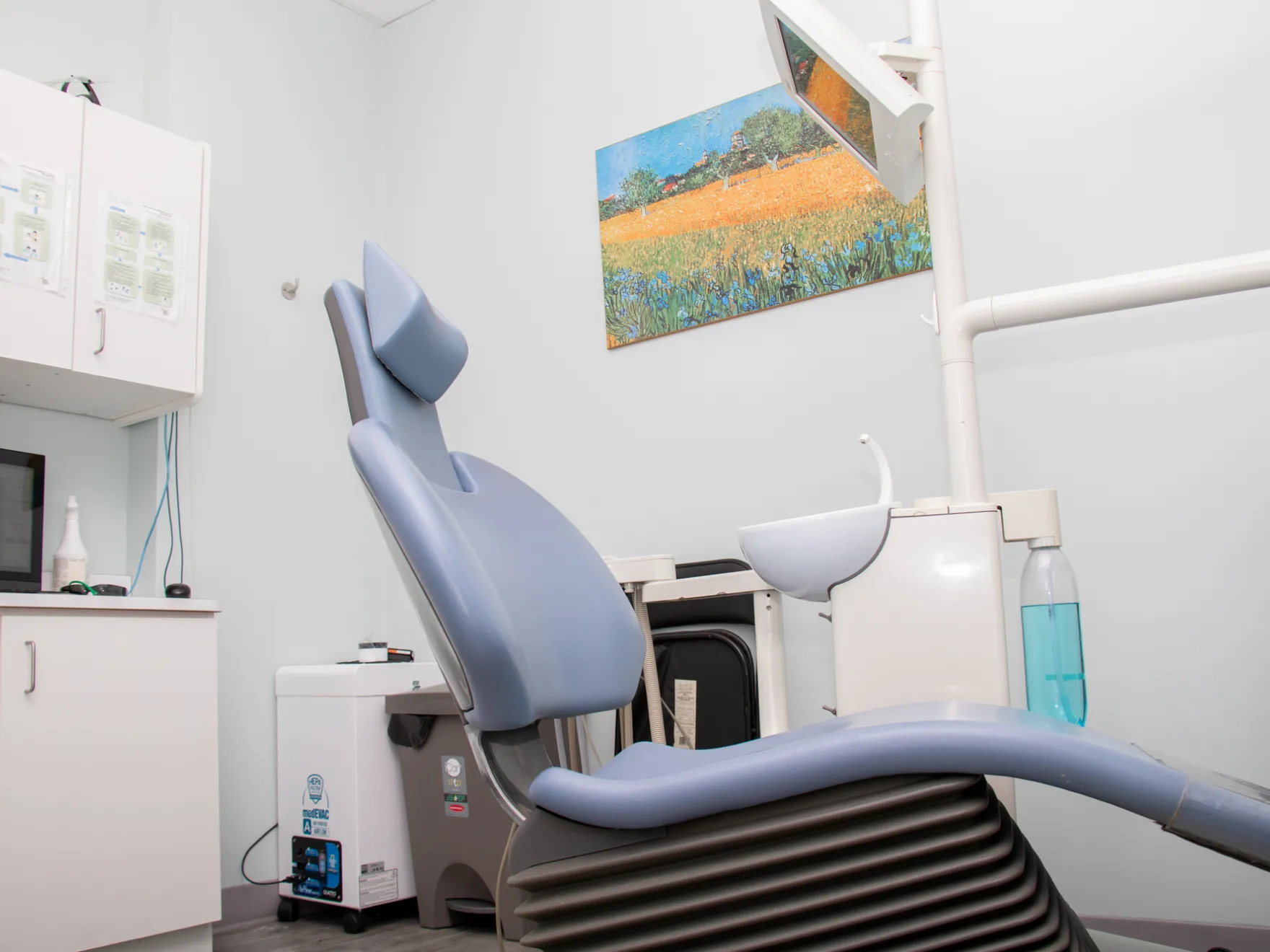 A dentist's office with a chair and a microwave.