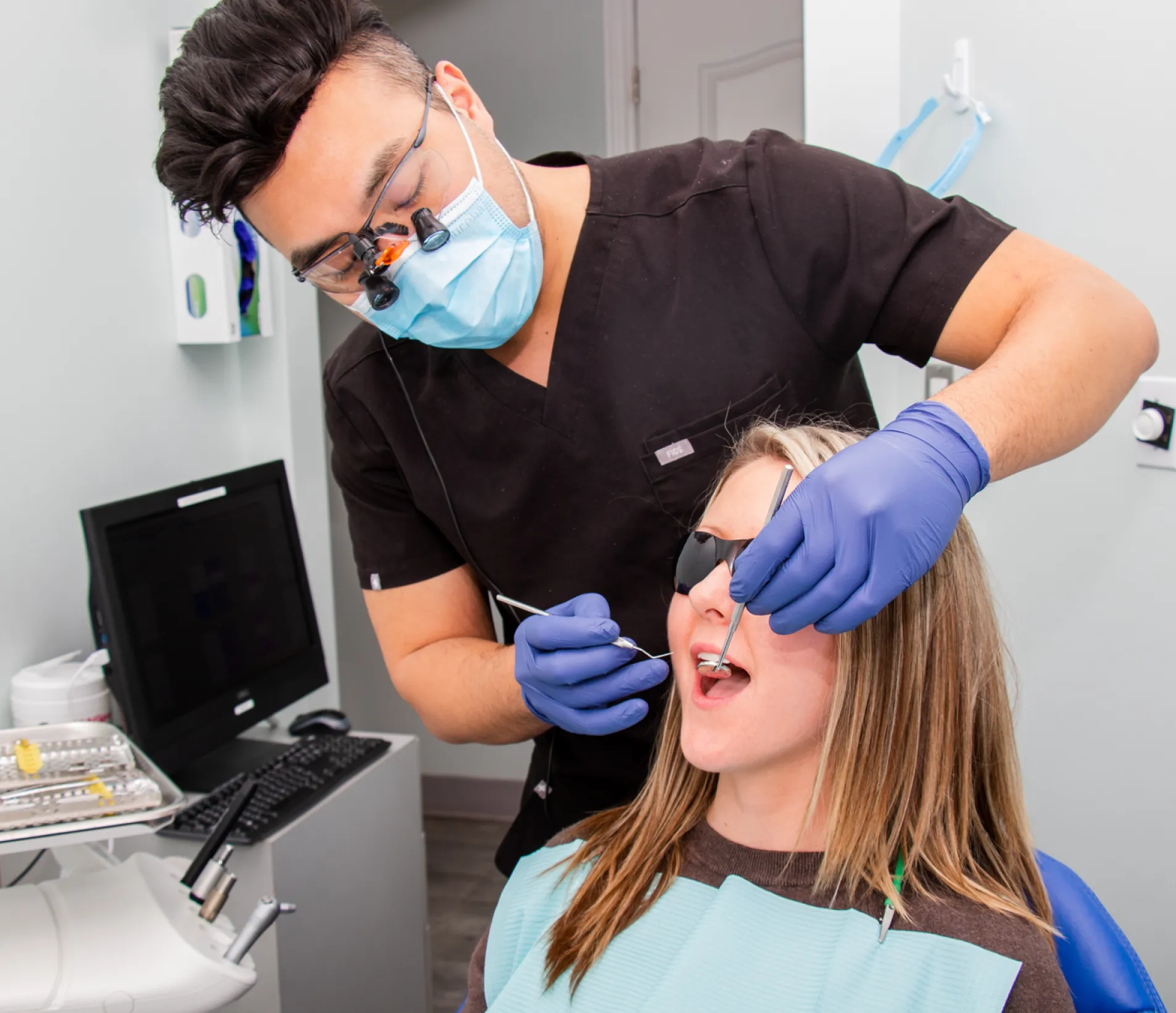 A woman getting her teeth checked by a dentist.