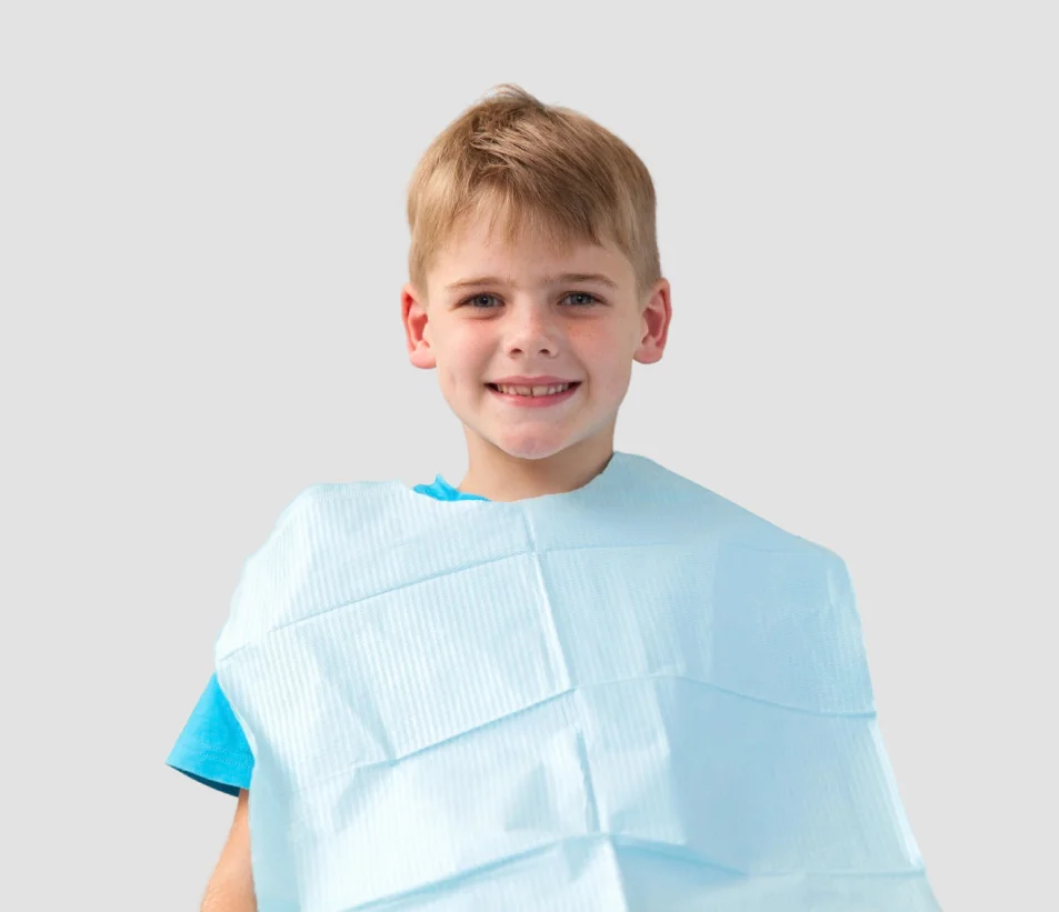 A young boy in a blue shirt holding a toothbrush.
