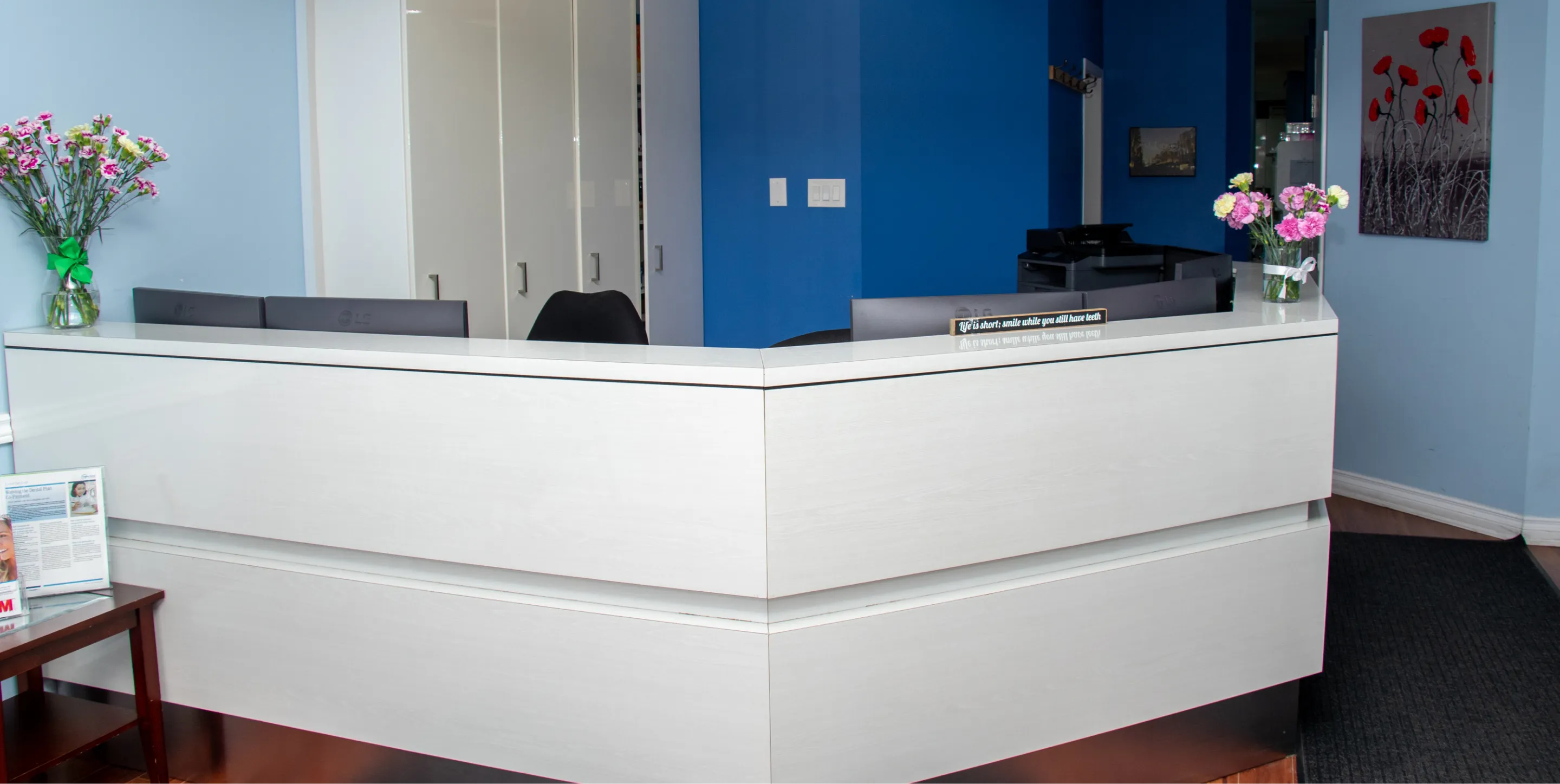 A dentist and patient smile and give thumbs up in a dental office.