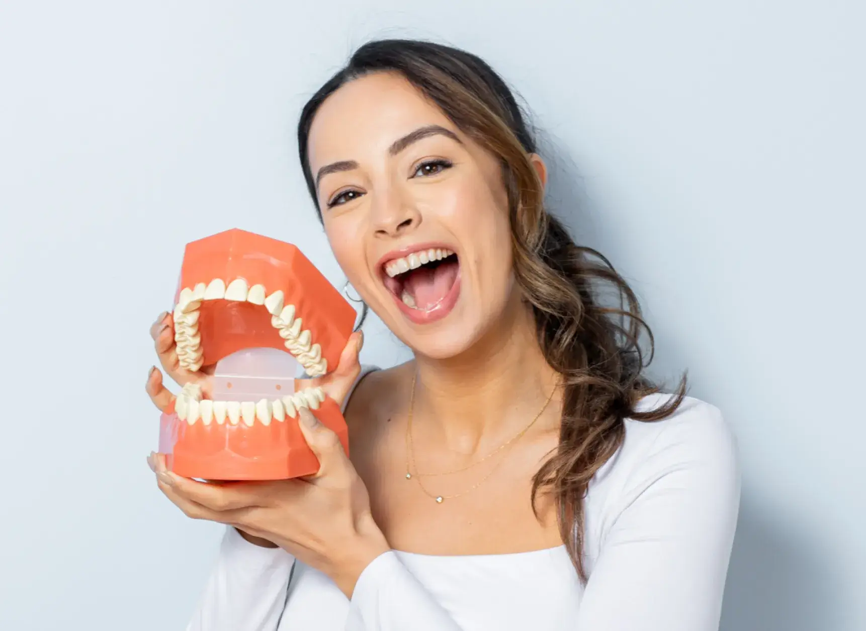 Family Dental Care of Tottenham team member smiling and holding a denture.