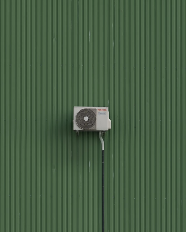 A green wall with a white and black object on it