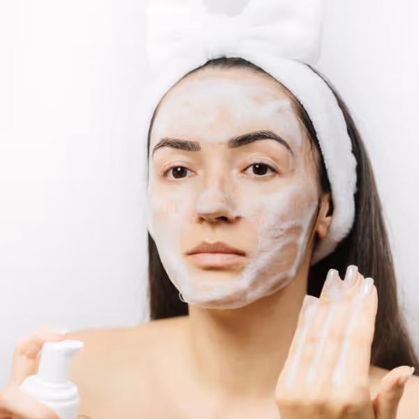 Woman applying facial cleanser during a skincare routine