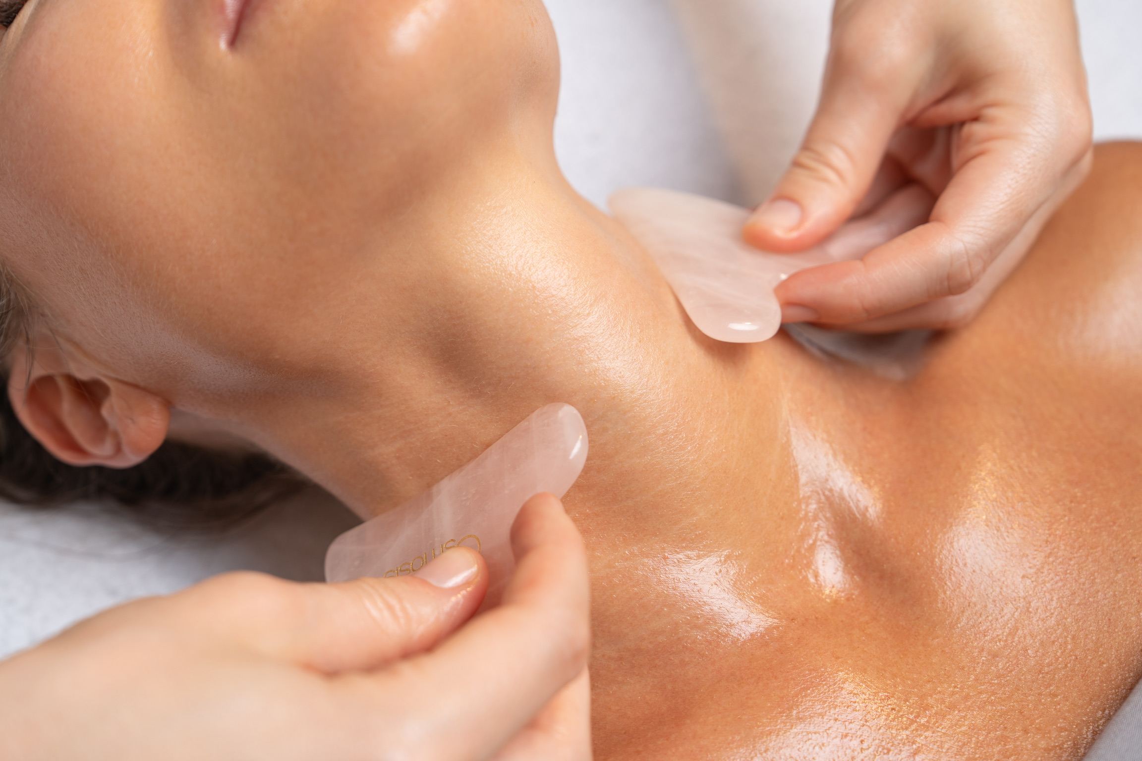  Rose quartz gua sha tools used during lymphatic drainage neck massage