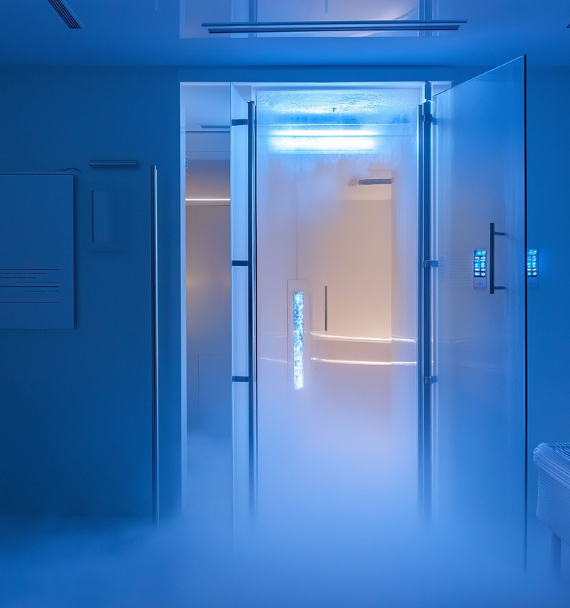 Woman with short wavy hair, eyes closed, peacefully facing sunlight against a clear blue sky.