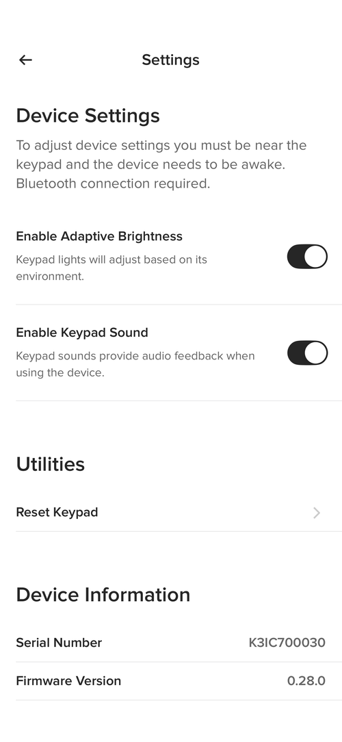 Settings screen showing device options to enable adaptive brightness and keypad sound, with serial and firmware info.
