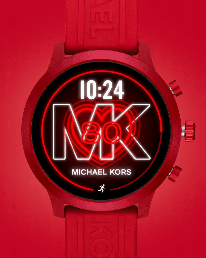 Red Michael Kors smartwatch displaying time 10:24 with heart icon and number 80 on screen.