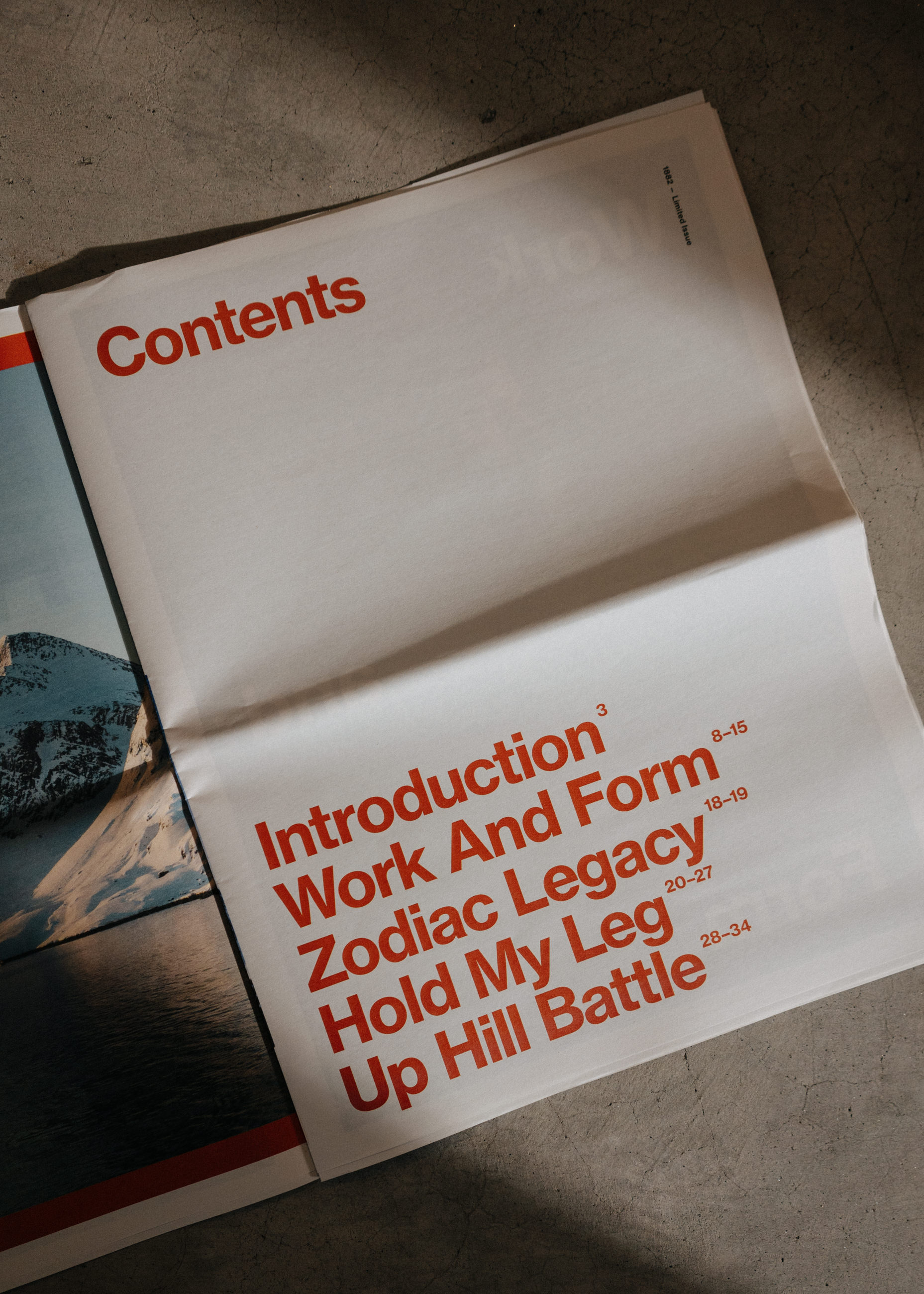 Open magazine showing a contents page with bold red section titles and page numbers.