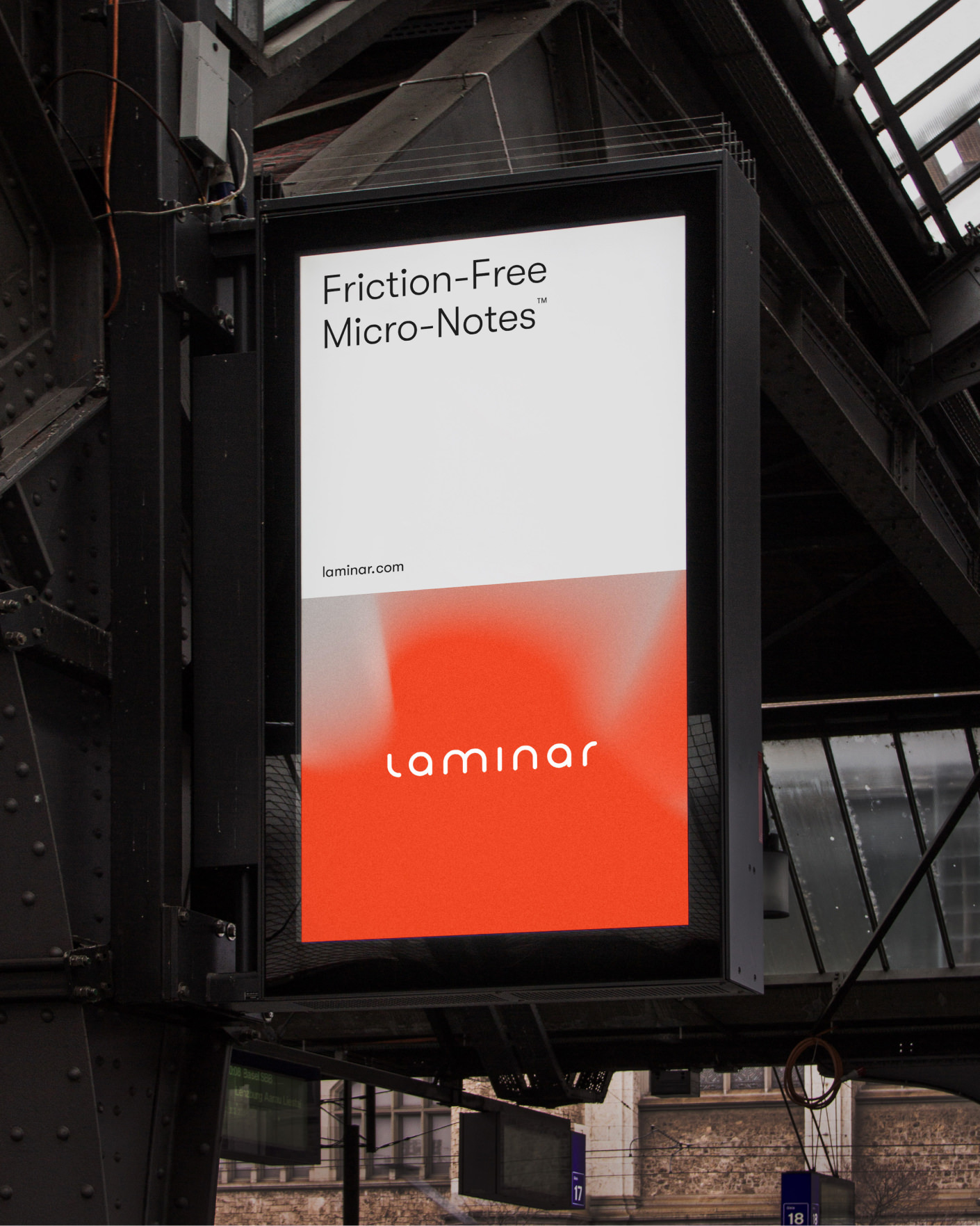 Outdoor digital billboard with white and orange ad for Laminar Friction-Free Micro-Notes.