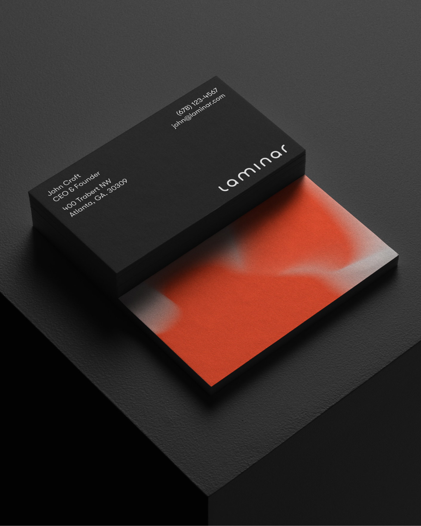 Stack of black business cards with white text for John Croft of Laminar, showing contact and address details.