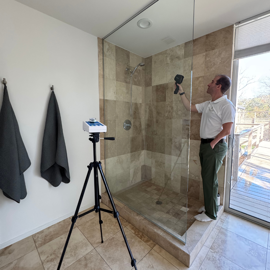 A man's back while holding in his hand air testing equipment