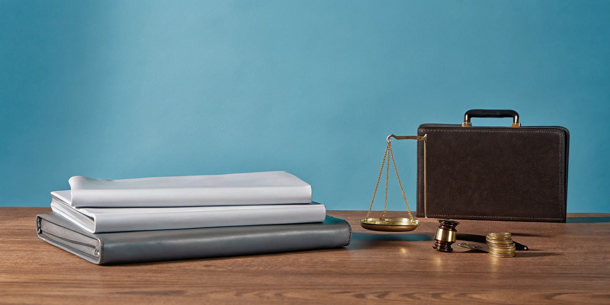 A lawyer's desk with a gavel, scales of justice, and coins for a case using contingency fees.