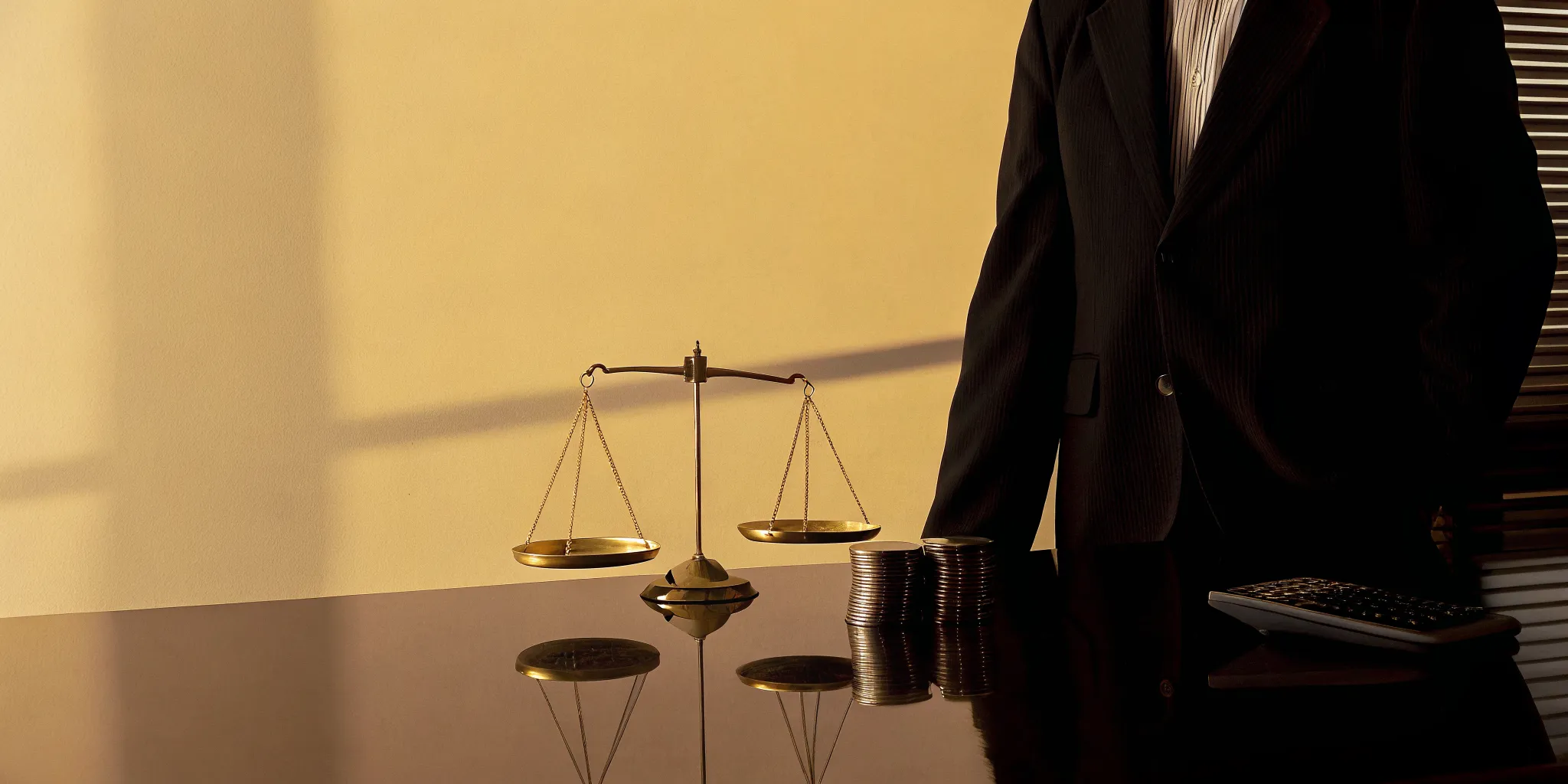 Calculator and scales of justice weighing the value of a personal injury case.