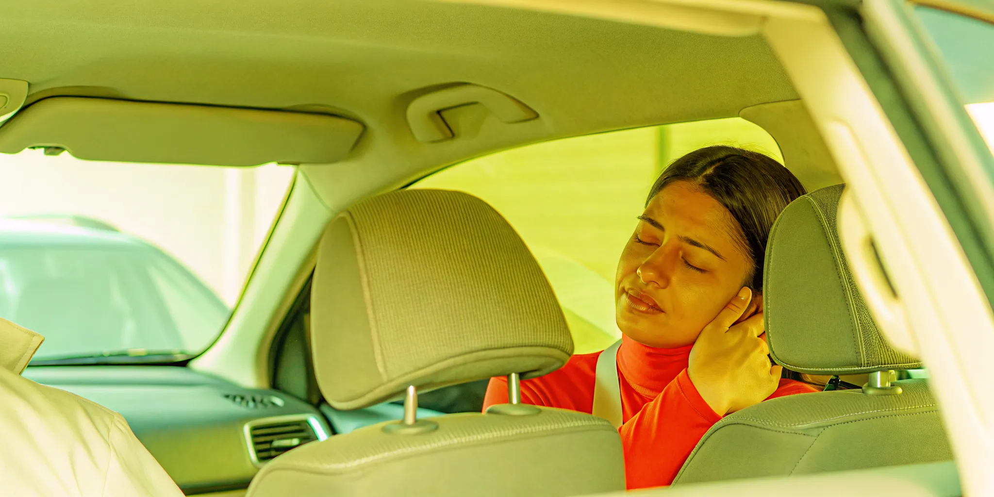 Person holding their neck after a rear-end car collision